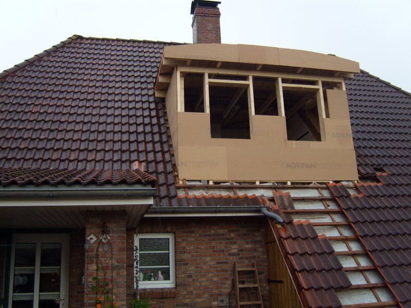 Ein Backsteinhaus mit einem Dach, das renoviert wird