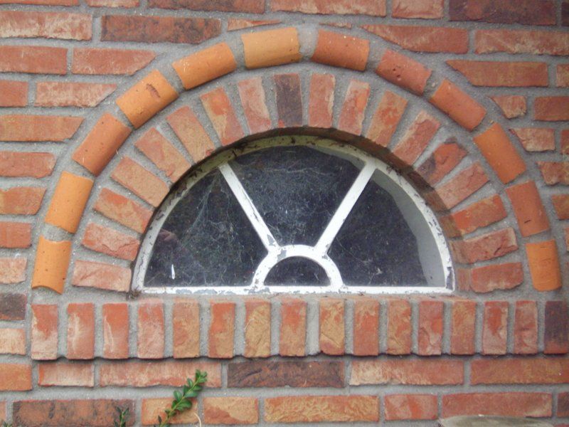 Eine Ziegelwand mit einem kleinen Fenster in der Mitte