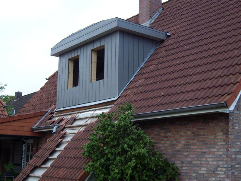 Ein Backsteinhaus mit einem Dach, auf dem sich ein Fenster befindet