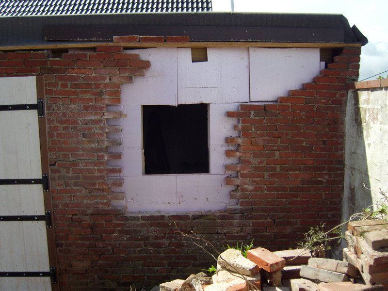 Eine Ziegelwand mit einem kleinen Fenster darin