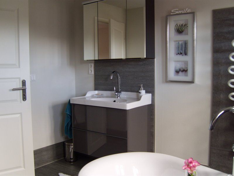 Ein Badezimmer mit Waschbecken, Badewanne und Spiegel