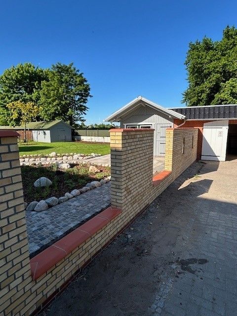 Eine Backsteinmauer mit einer Garage im Hintergrund