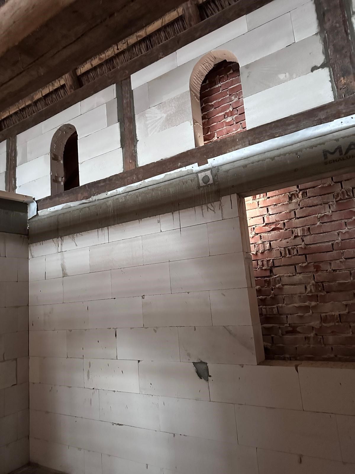 Ein Raum mit einer Ziegelwand und einer weißen Wand.