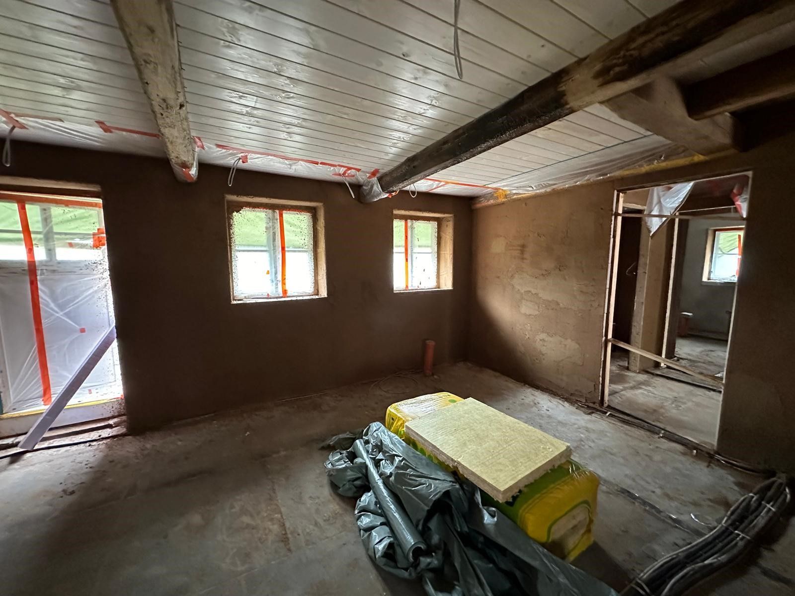 Ein Raum mit vielen Fenstern und einer Holzdecke.