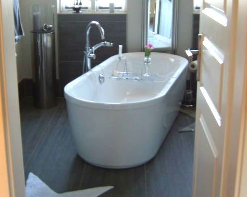 Ein Badezimmer mit Badewanne und Spiegel