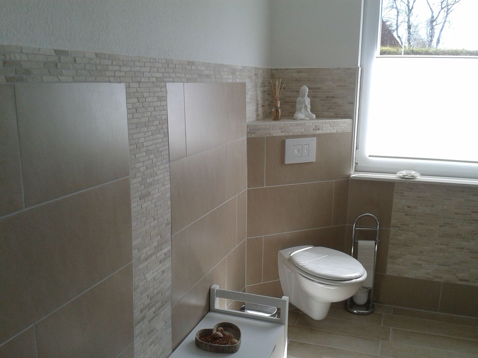 Ein Badezimmer mit Wand-WC und Fenster