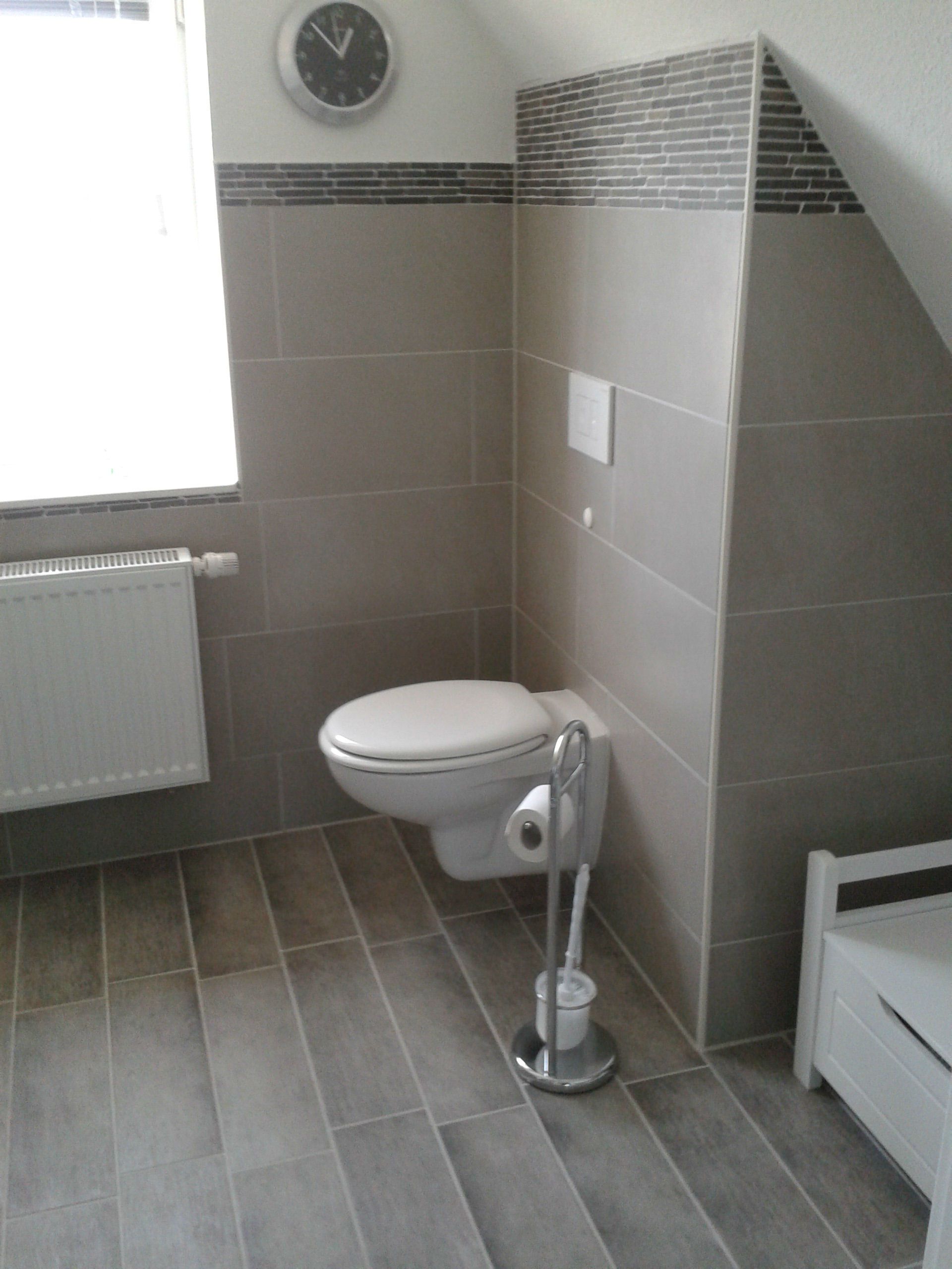 Ein Badezimmer mit Toilette und einer Uhr an der Wand