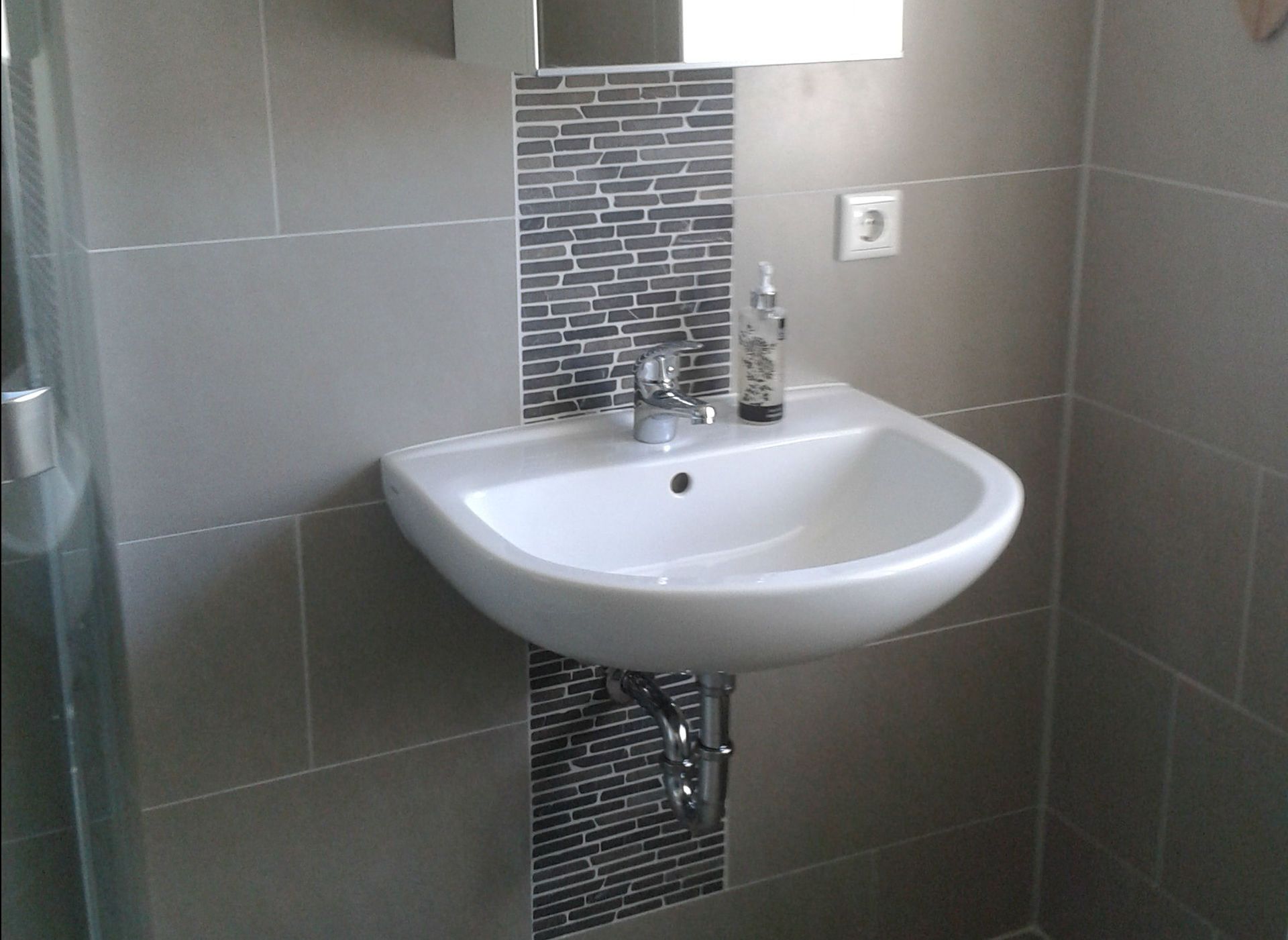 Ein Badezimmer mit Waschbecken und Spiegel