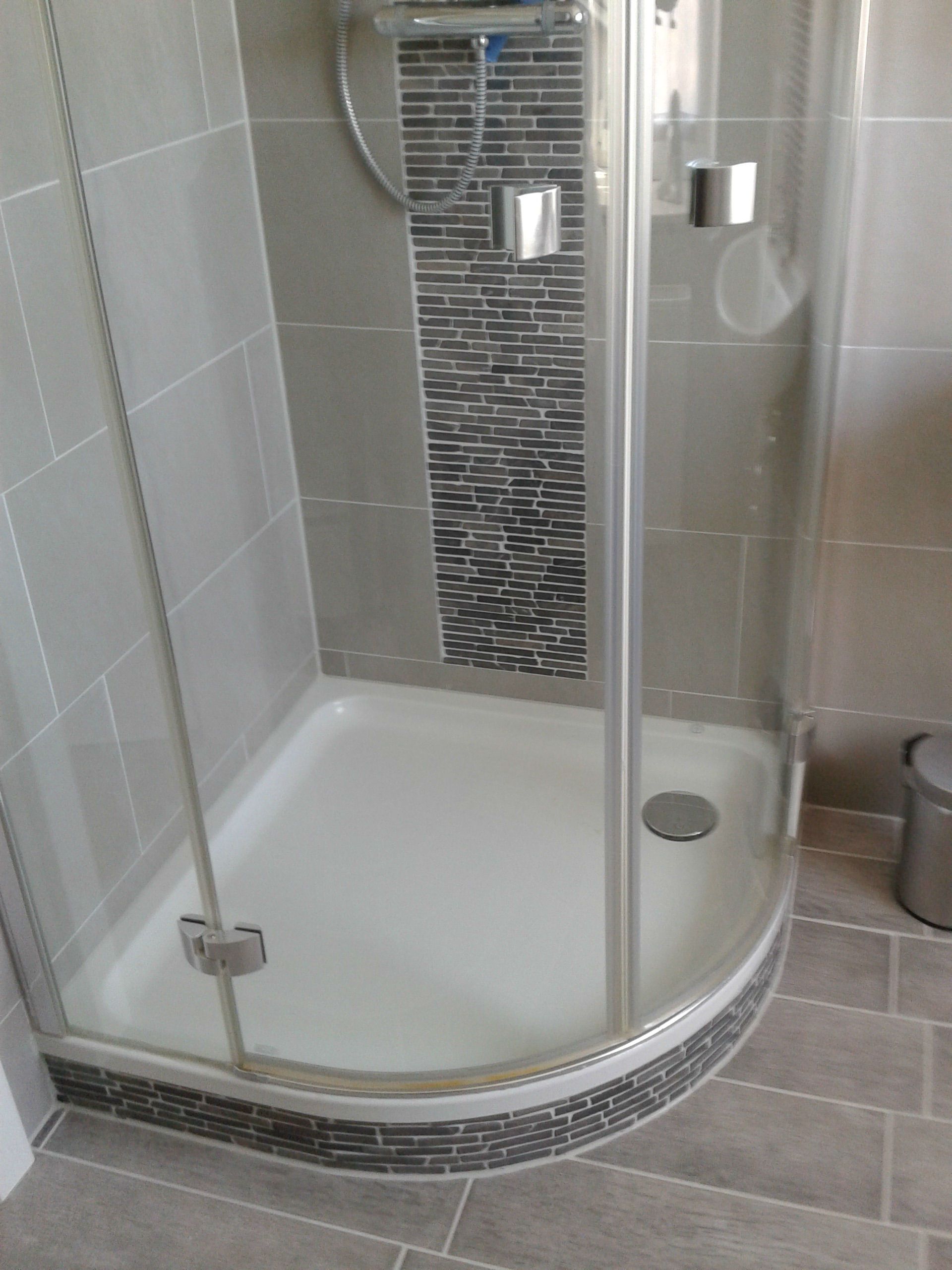 Ein Badezimmer mit Duschkabine und Mülleimer