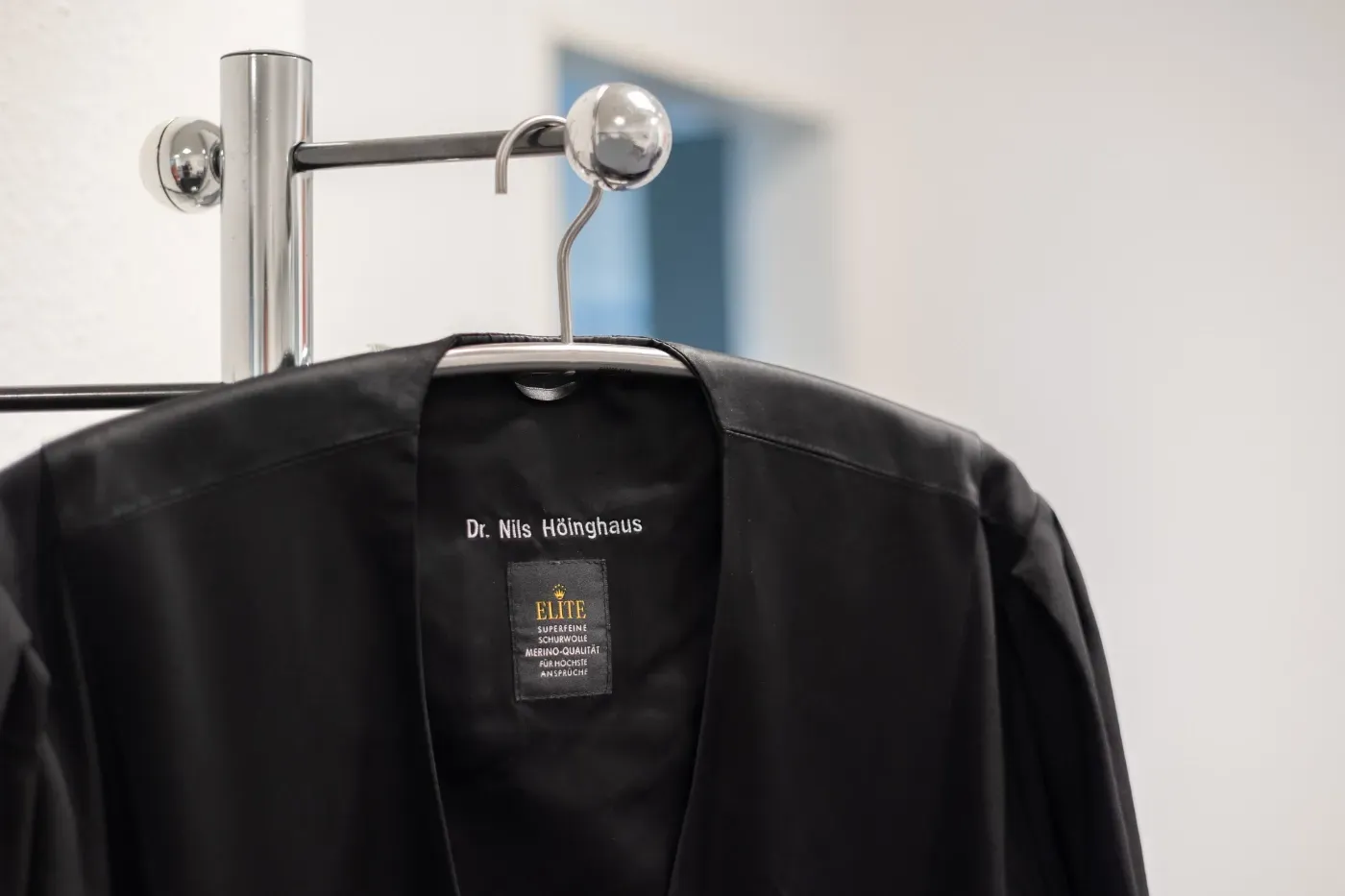 Schwarze Jacke auf einem Kleiderständer, Nahaufnahme von Kragen und Etikett