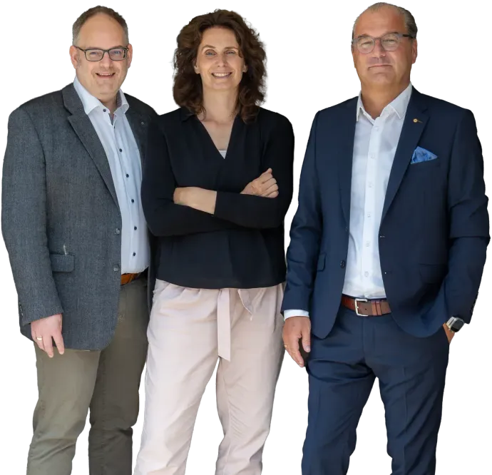 Drei Personen in Businesskleidung posieren gemeinsam vor einem weißen Hintergrund.