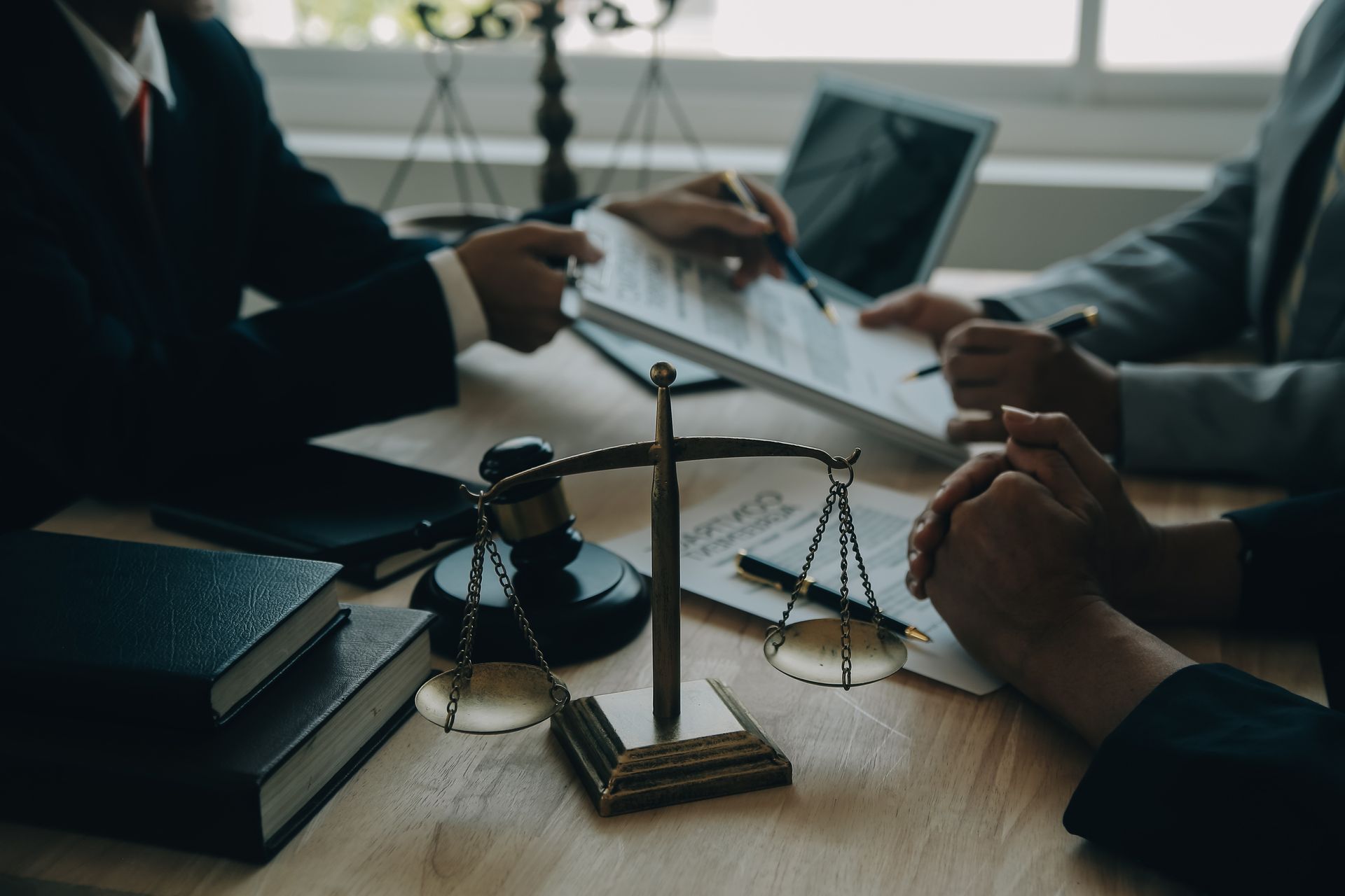 Abogados revisando documentos en un escritorio con balanza de la justicia y un mazo.