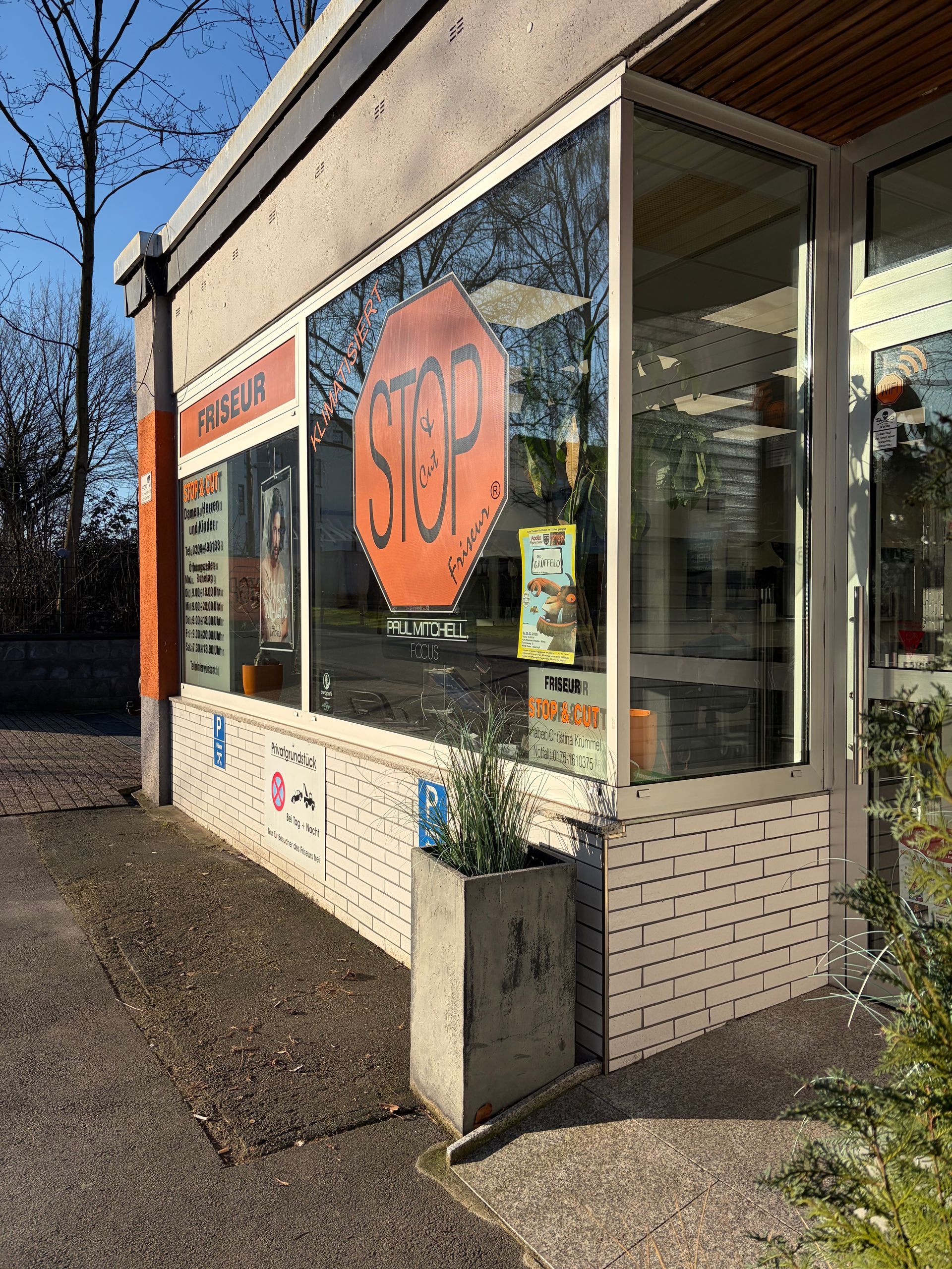 An der Außenecke prangt ein großer orangefarbener Aufkleber mit der Aufschrift „STOP“ auf der Glasscheibe.