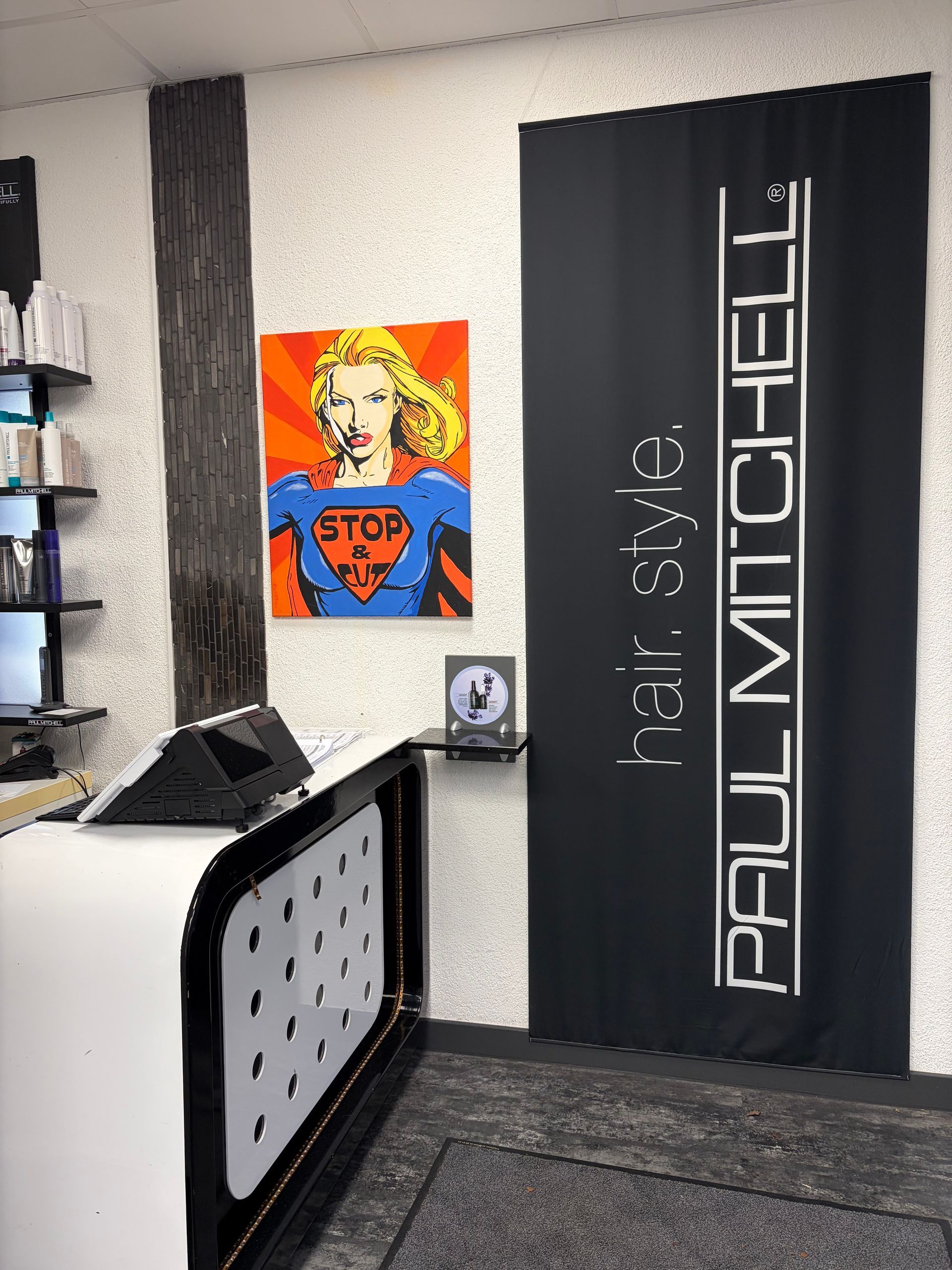 Ein moderner Salonempfangsbereich mit einem schwarz-weißen Schreibtisch und einem Superhelden-Pop-Art-Gemälde