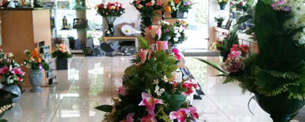 Des compositions florales dans un hall d'entrée intérieur lumineux avec des sols cirés et des plantes en pot