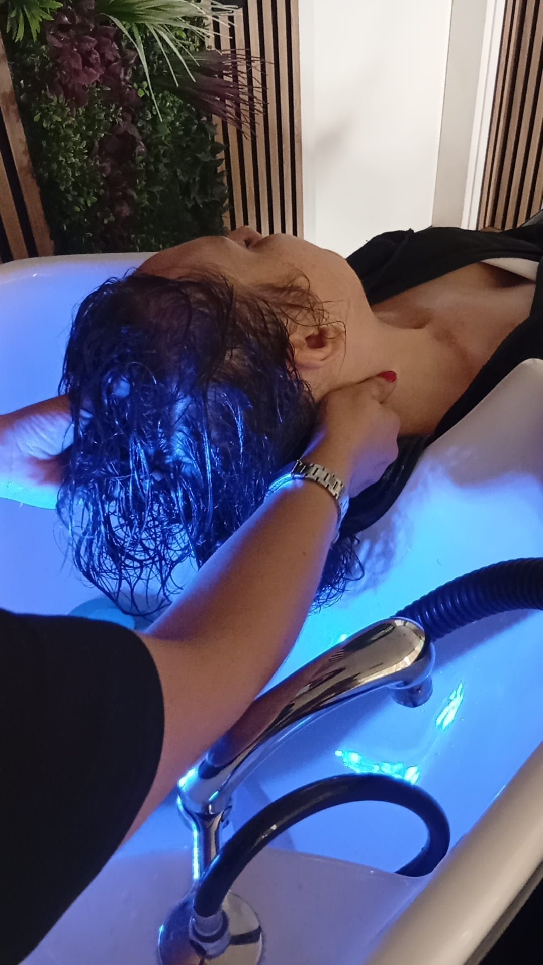 Primer plano del rostro de una persona recibiendo un masaje facial. Las manos están cerca de la boca y la barbilla.