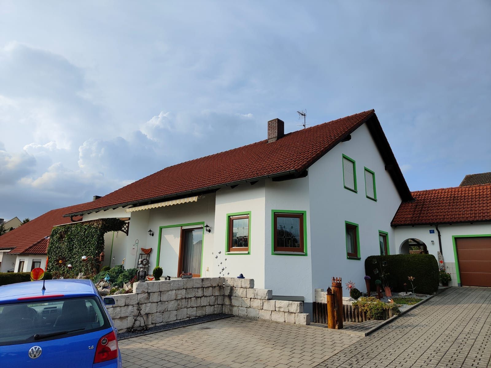 Großes, weißes Haus mit grünen Rahmen um den Fenstern und weißer Fassade