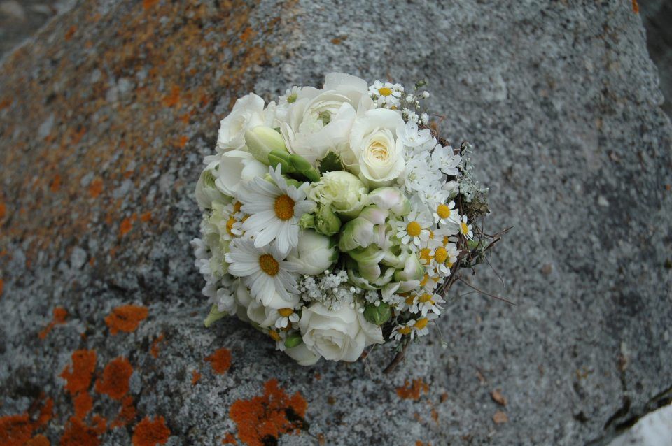Auf einem Stein liegt ein Strauss weisser Blumen. Foto vom Blumen-Atelier BACCARA