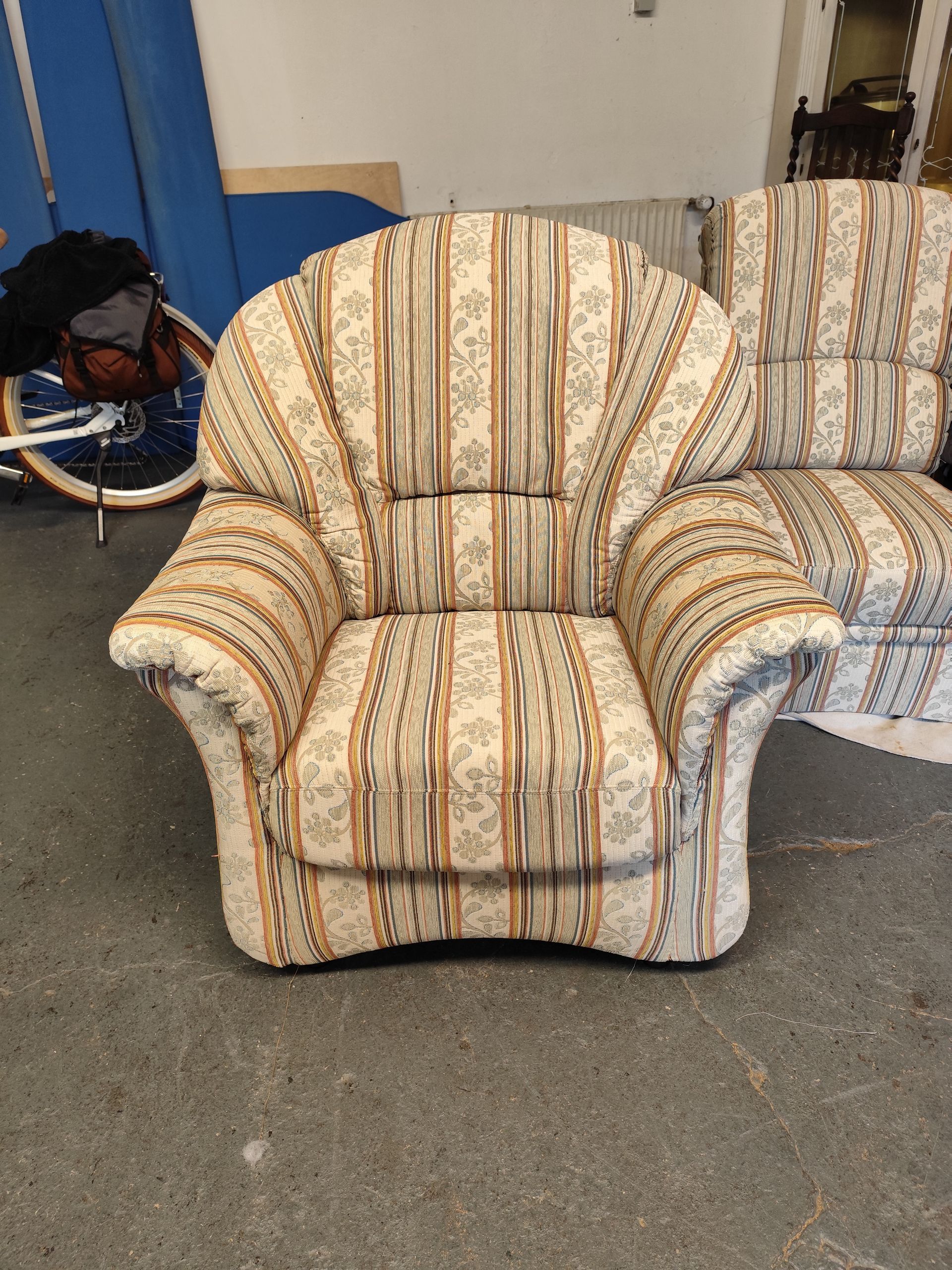 Sessel- und Couchgarnitur mit beige gestreiftem Polsterbezug.