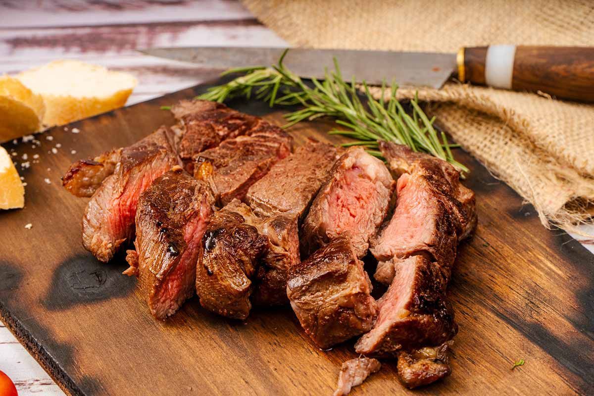 Un trozo de filete reposa sobre una tabla de cortar de madera.