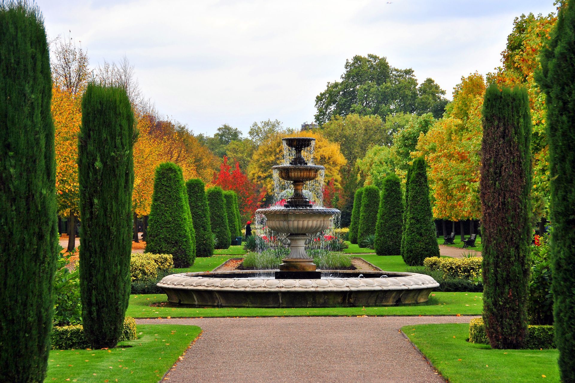 Fontaine au milieu d'une allée avec des tuyas.