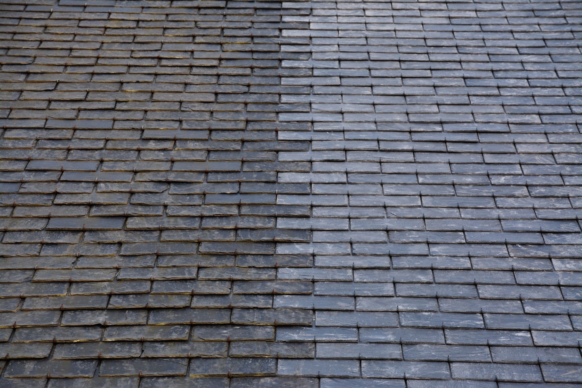 Différence de rendu avant et après rénovation d'une toiture en ardoise.