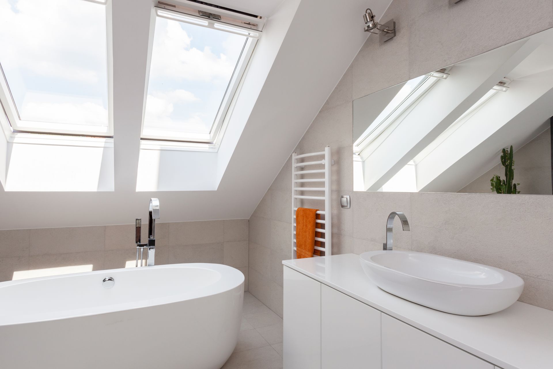 Salle de bain sous un toit en pente avec deux Velux.