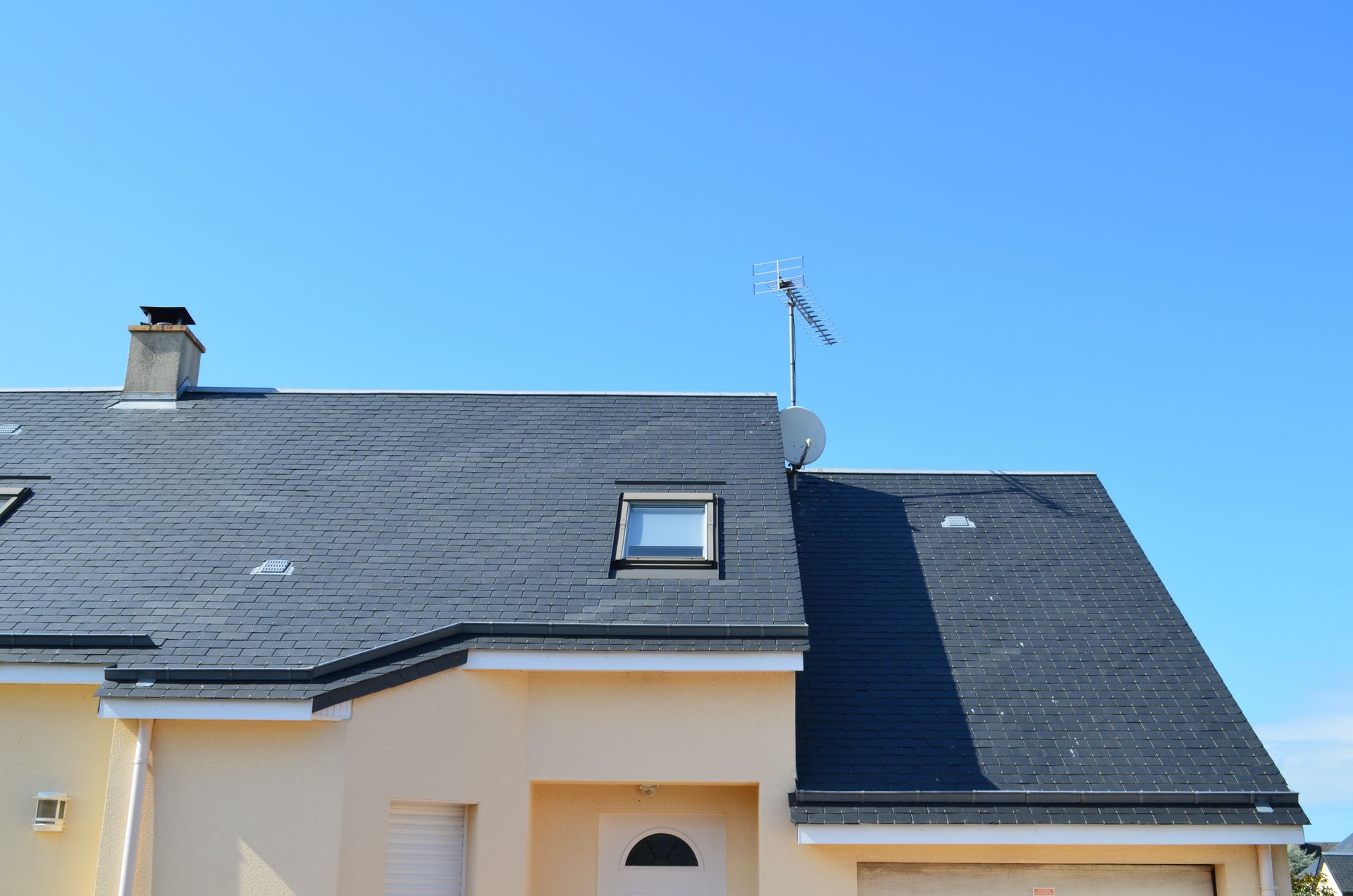 Maison de plain-pied avec toiture en ardoise.