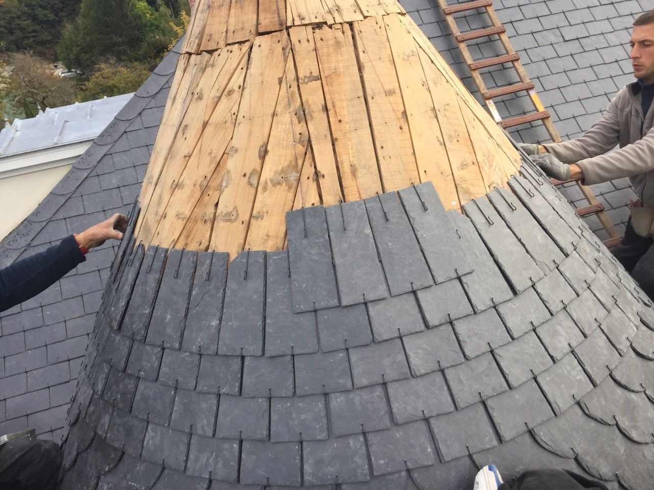 Deux professionnels sur un chantier de rénovation de toiture.