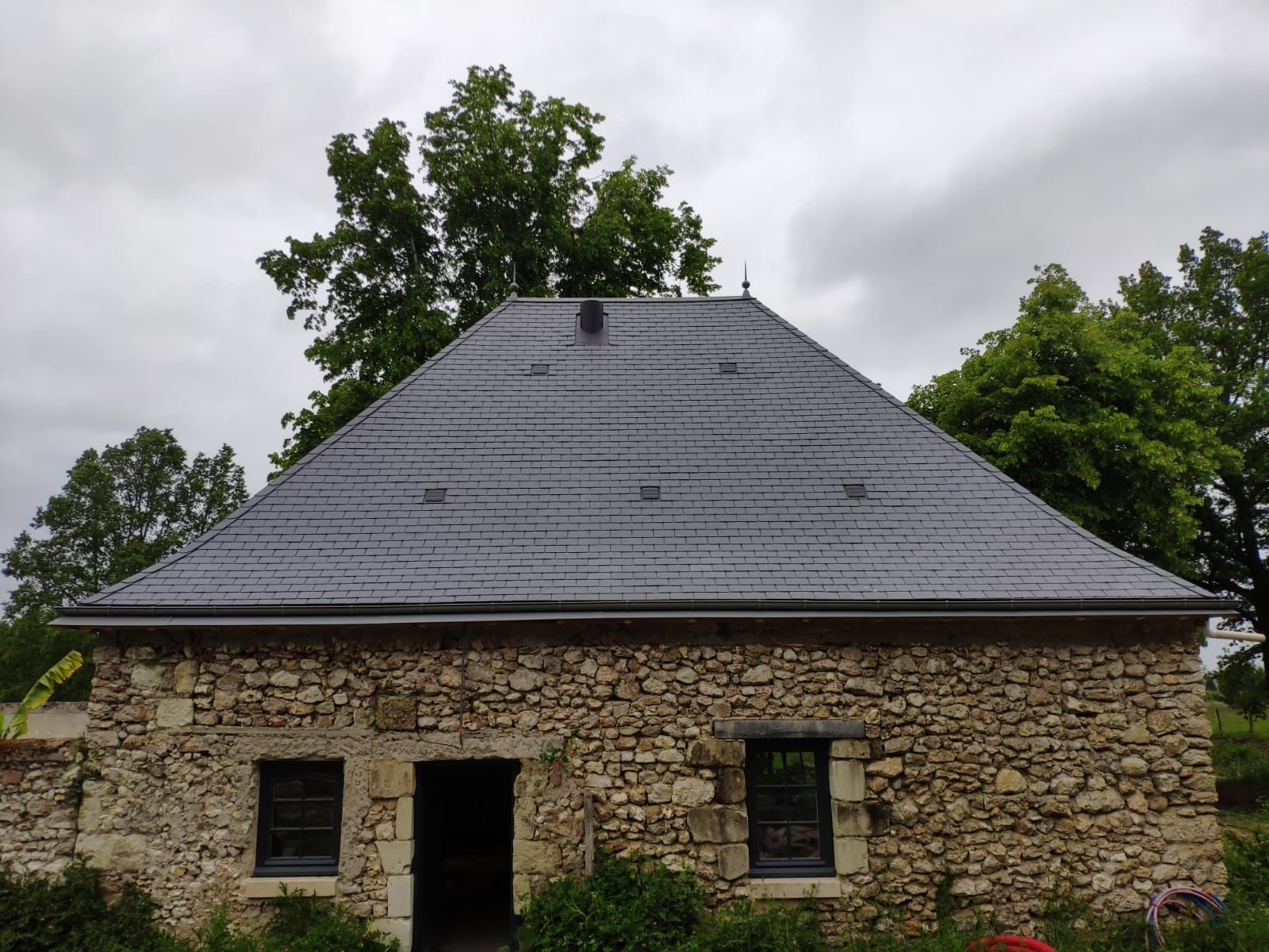 Maison en pierre avec toiture rénovée.