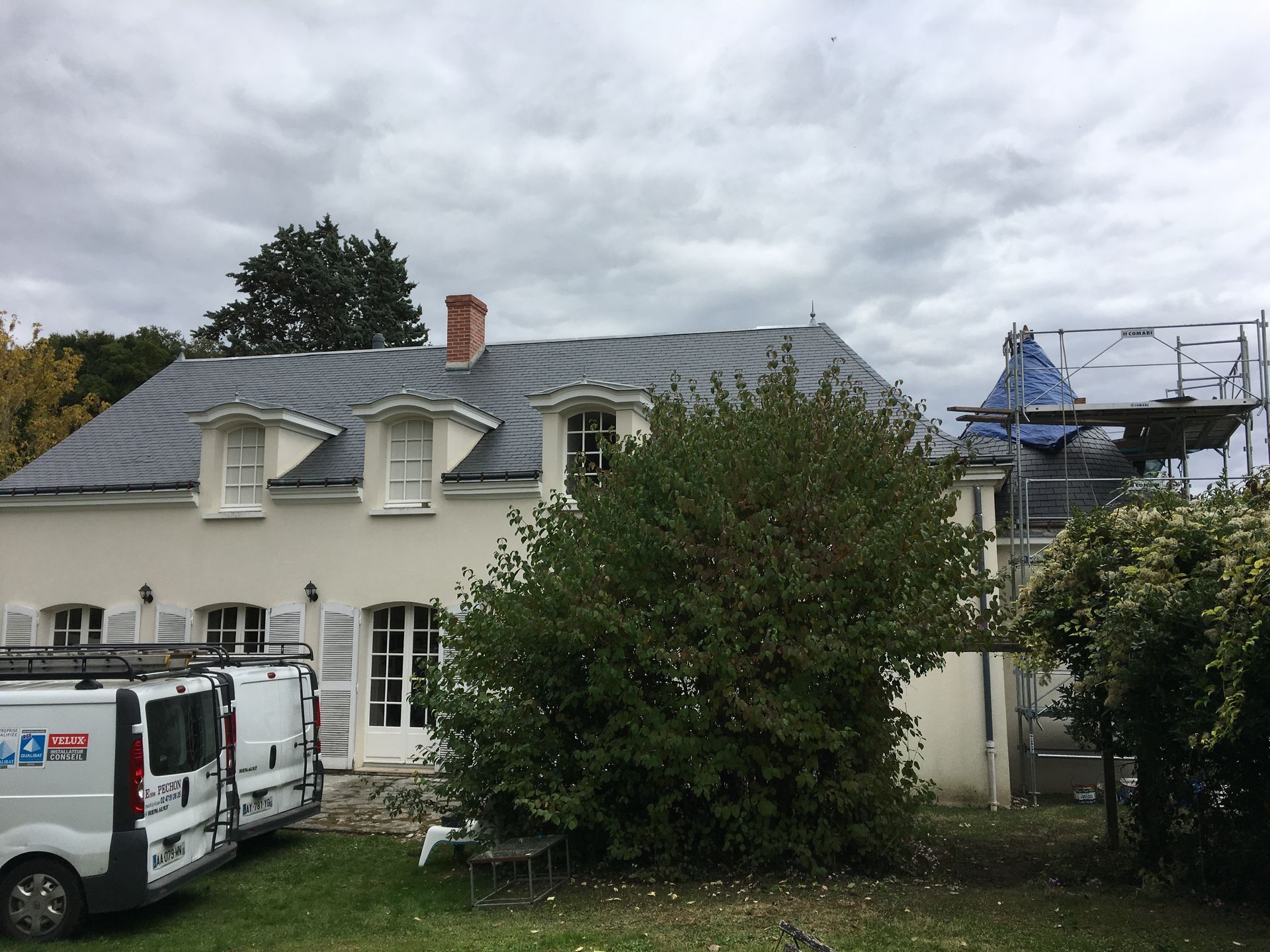 Chantier de travaux de toiture avec des camions de l'entreprise Péchon.