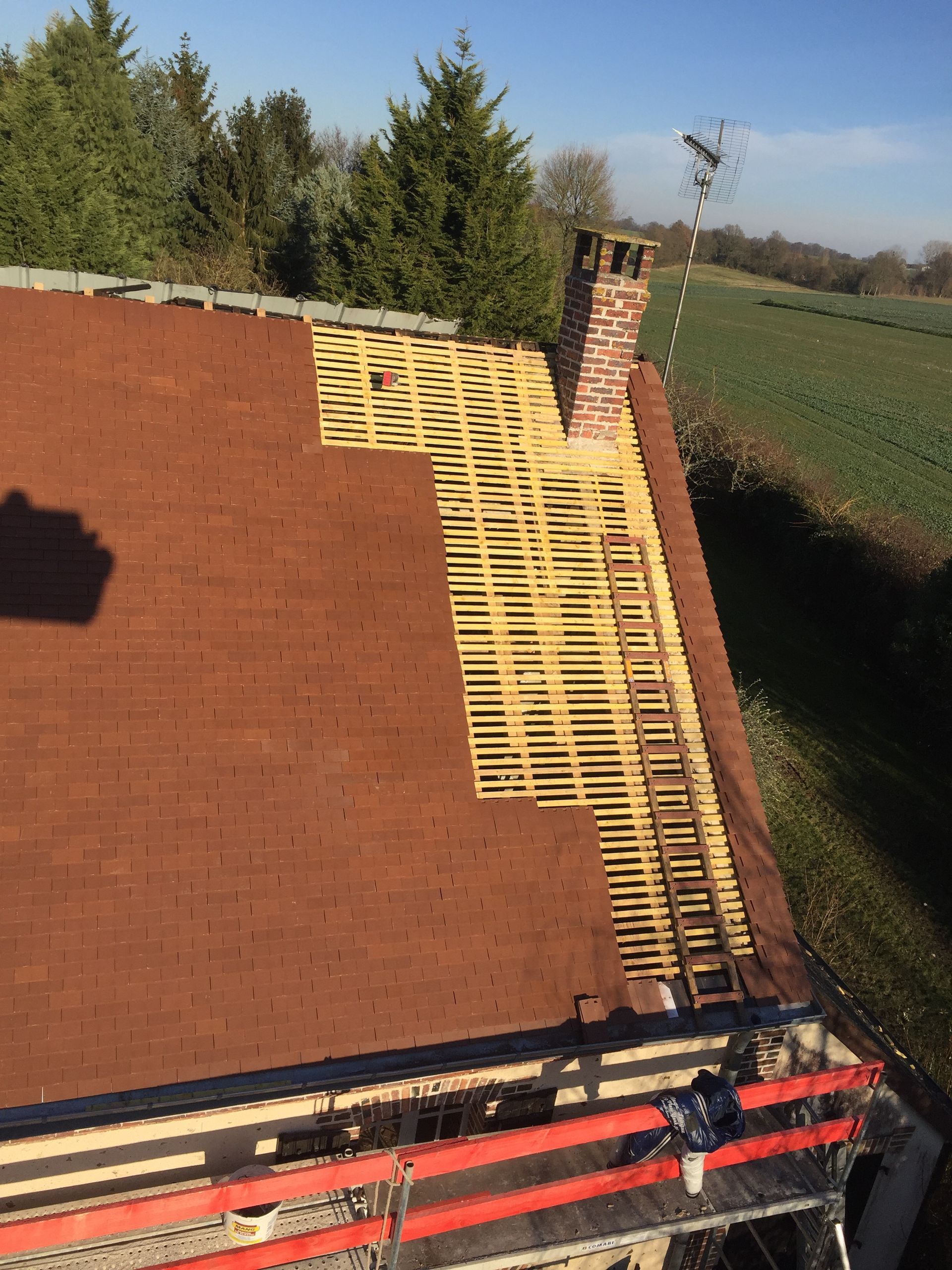 Vue aérienne d'une toiture dont la partie droite n'a pas encore de tuiles.