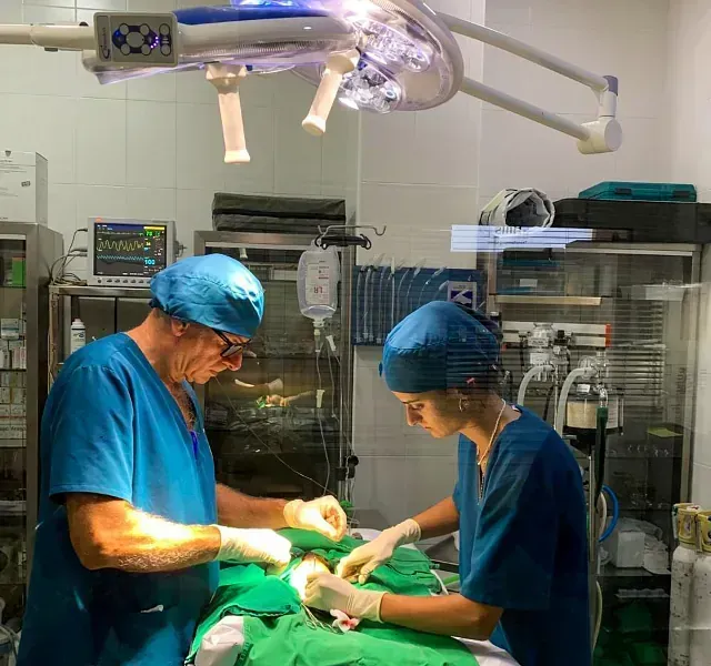 Dos cirujanos están trabajando con un paciente en un quirófano.
