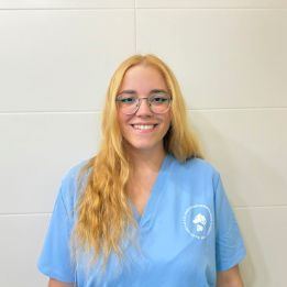 Una mujer que lleva una máscara sostiene un animal de peluche.