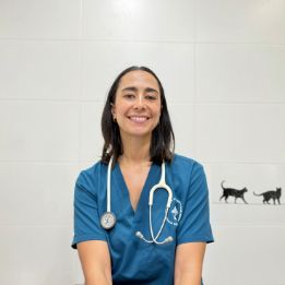Una mujer que lleva una máscara sostiene un cachorro en sus brazos.