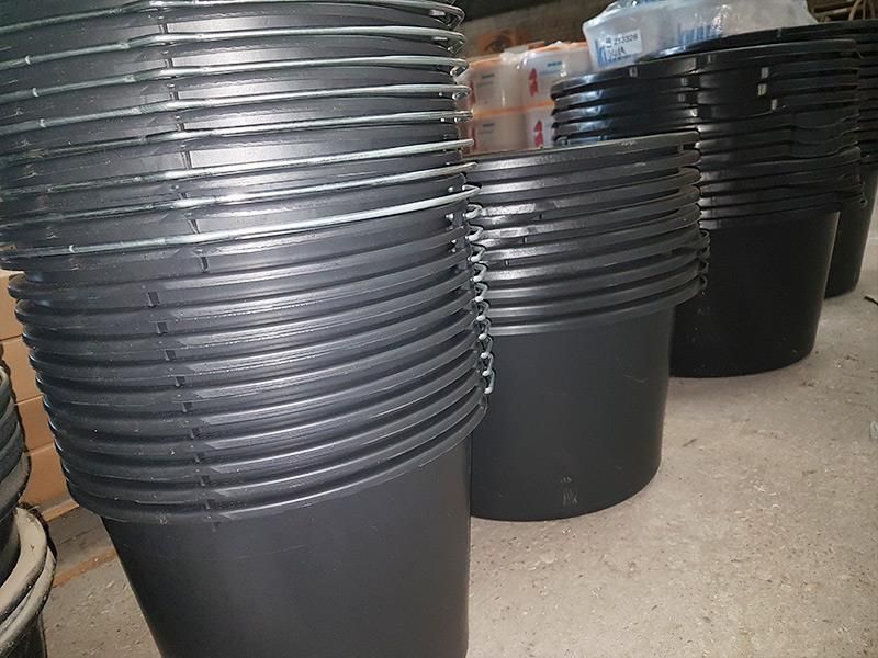 Ein Haufen schwarzer Plastikeimer sind übereinander gestapelt