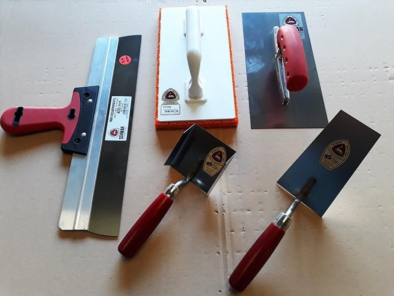 Eine Gruppe von Werkzeugen, darunter ein Spachtel und eine Kelle