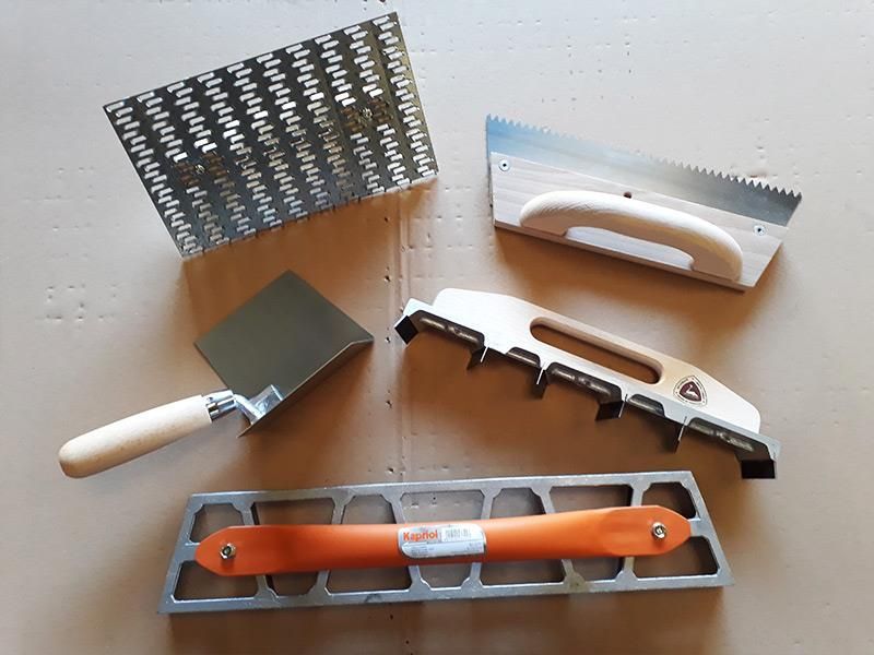 Ein Haufen Werkzeuge auf einem Tisch, darunter eine Kelle