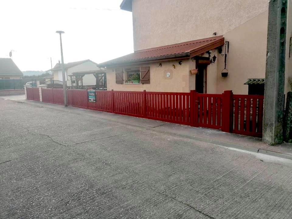 Photo d'une clôture et d'un portail rouges