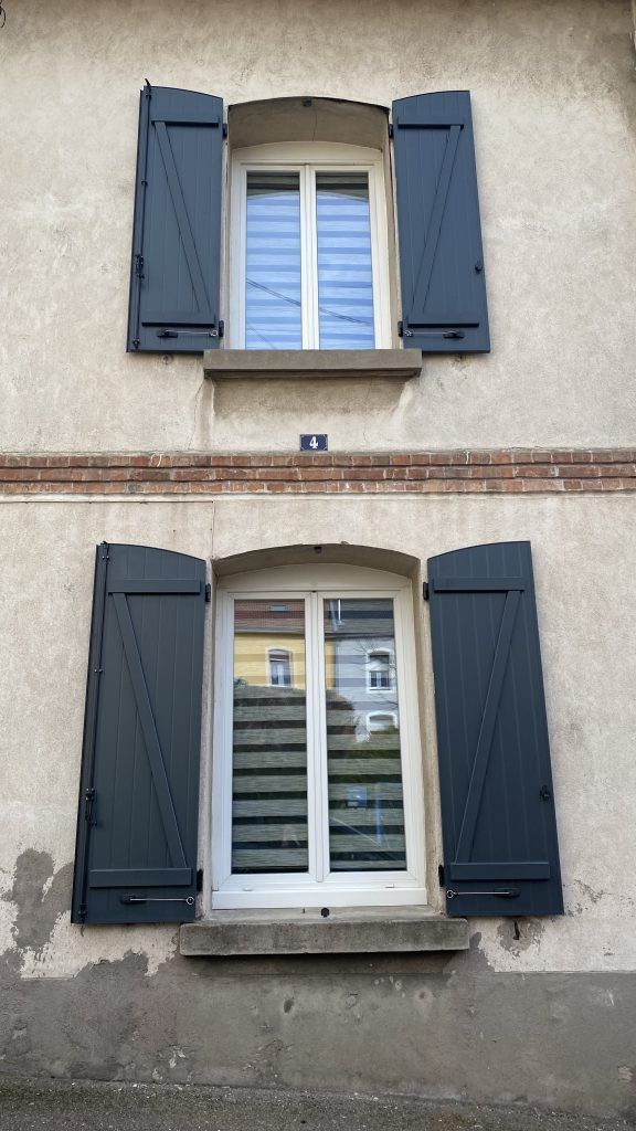 Photo de fenêtres neuves vue de l'extérieur avec des volets en bois bleus