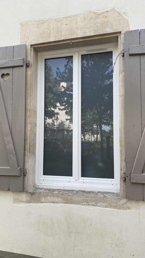 Photo d'une fenêtre neuve avec des volets en bois gris