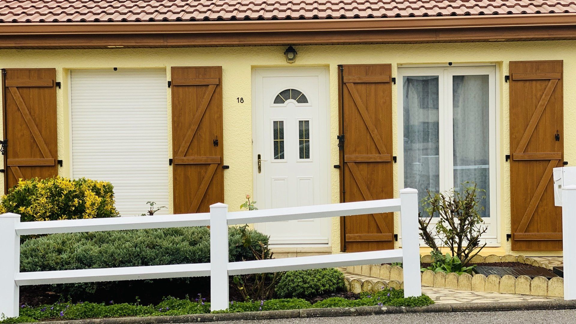 Photo d'un façade de maison avec des volets en bois