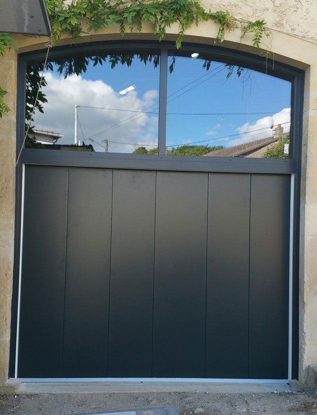 Photo d'une porte de garage grise avec espace vitré au sommet