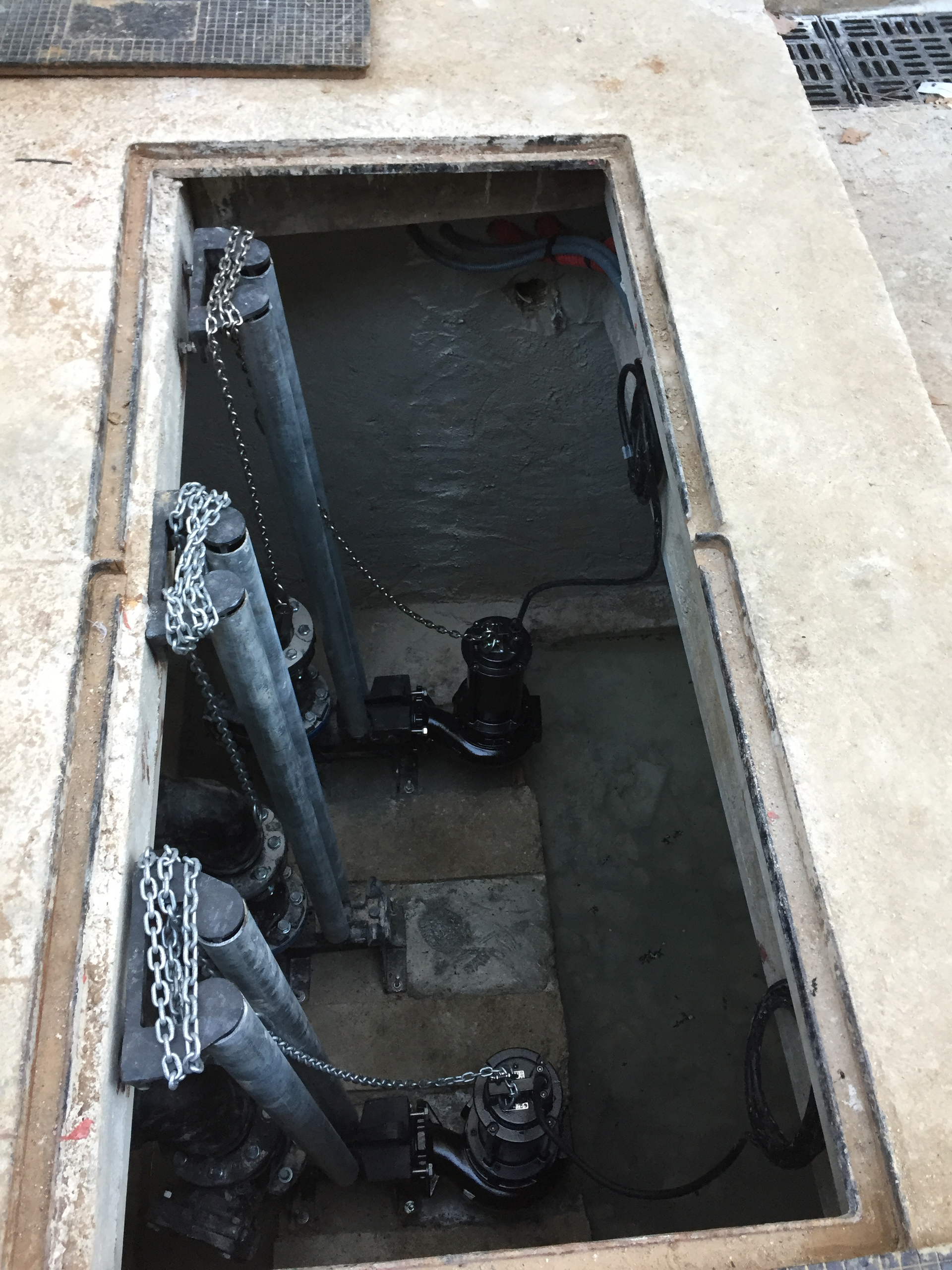 Un couvercle de trou d'homme avec une pompe à l'intérieur.