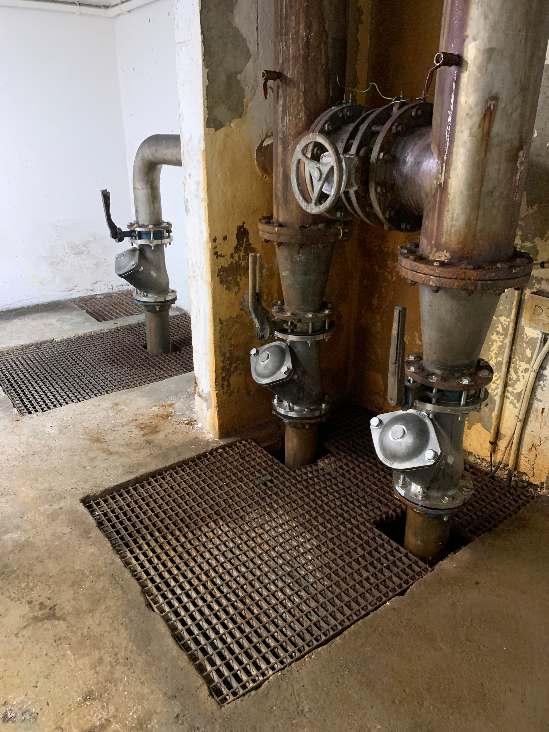 Une pièce avec beaucoup de tuyaux et de vannes sur le sol