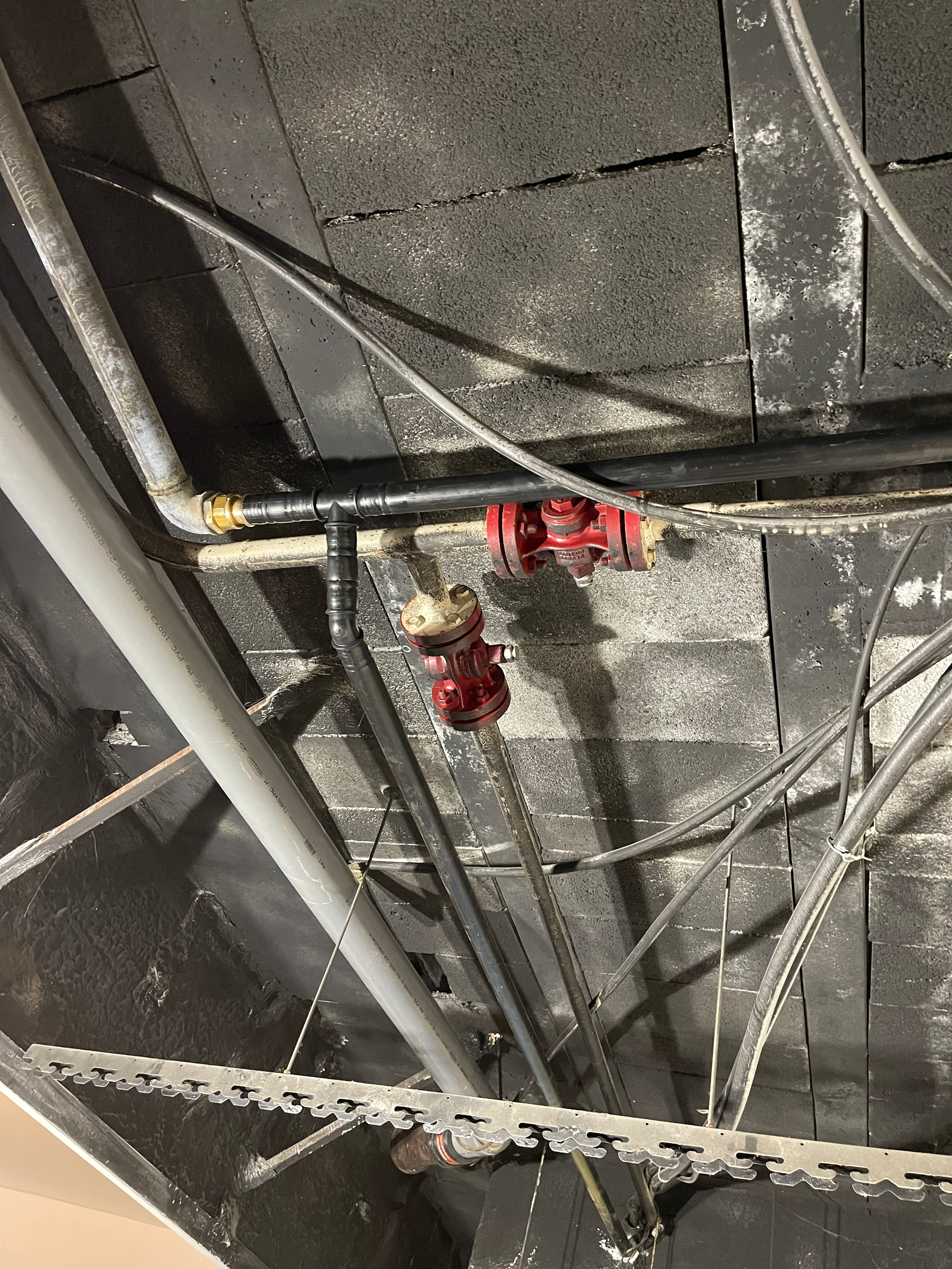 Un tas de tuyaux pendent du plafond d'un bâtiment.