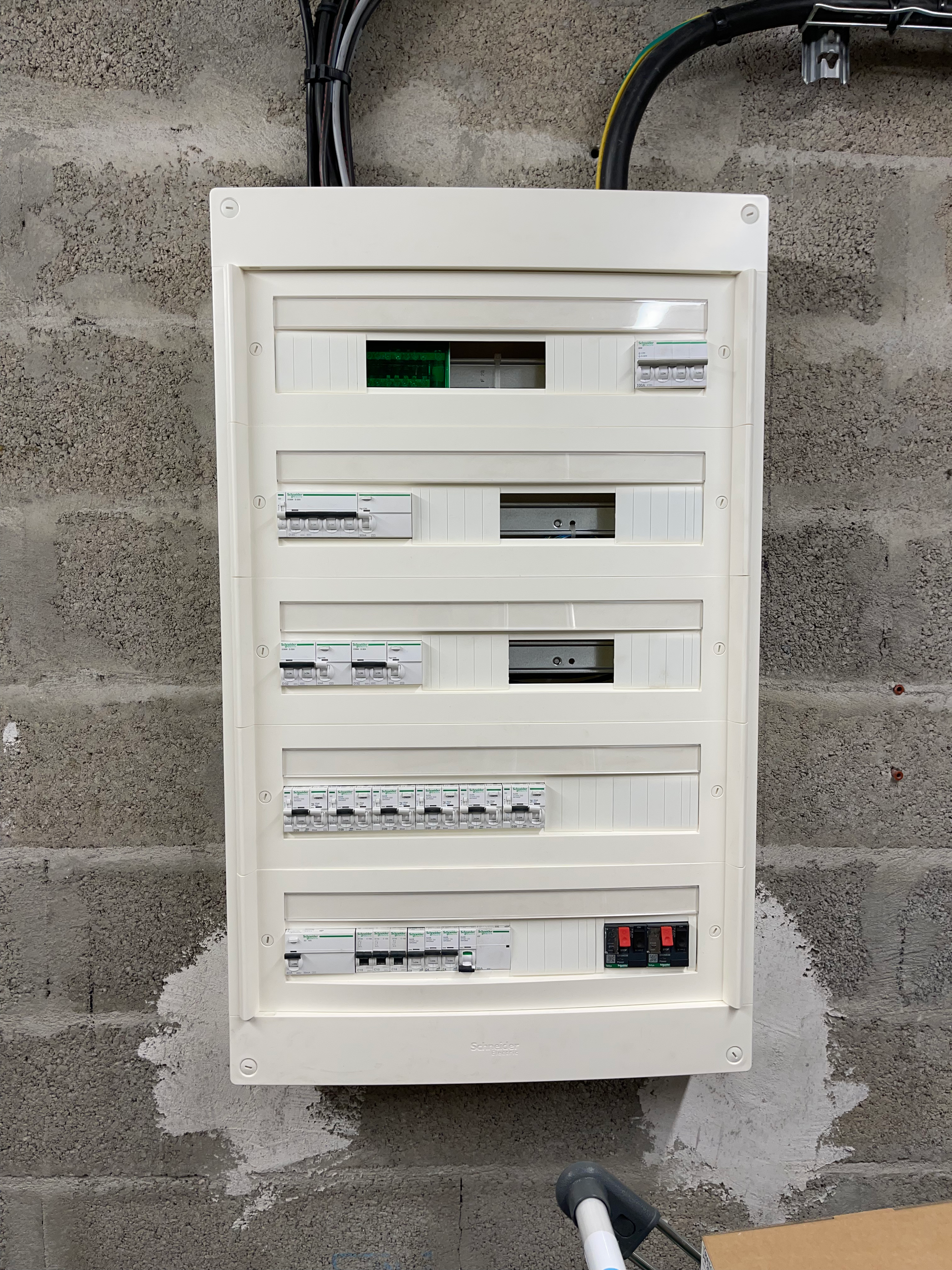 Un boîtier électrique blanc est accroché à un mur de briques.