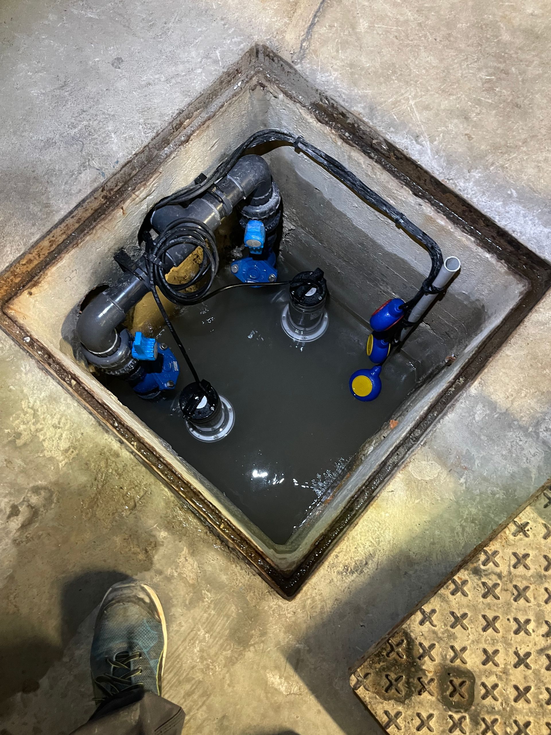 Un couvercle de trou d'homme rempli d'eau et de pompes.