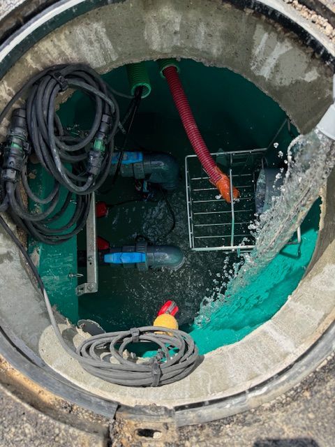 Un couvercle de trou d'homme avec de l'eau qui en sort.