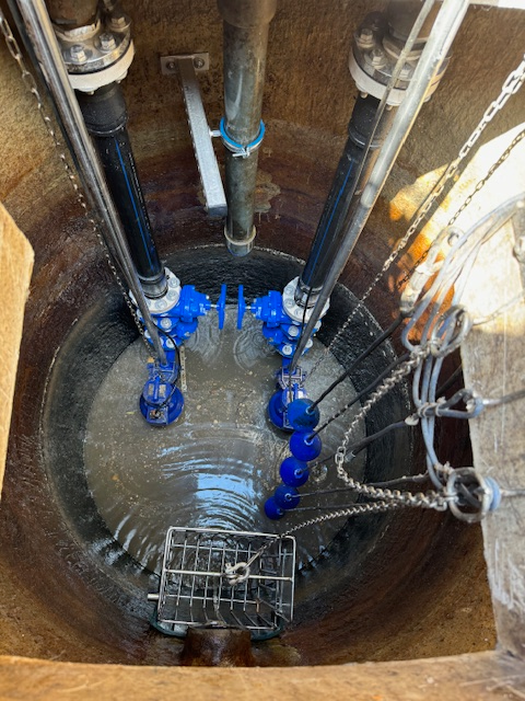 Un regard d'égout avec un tas de tuyaux qui en sortent